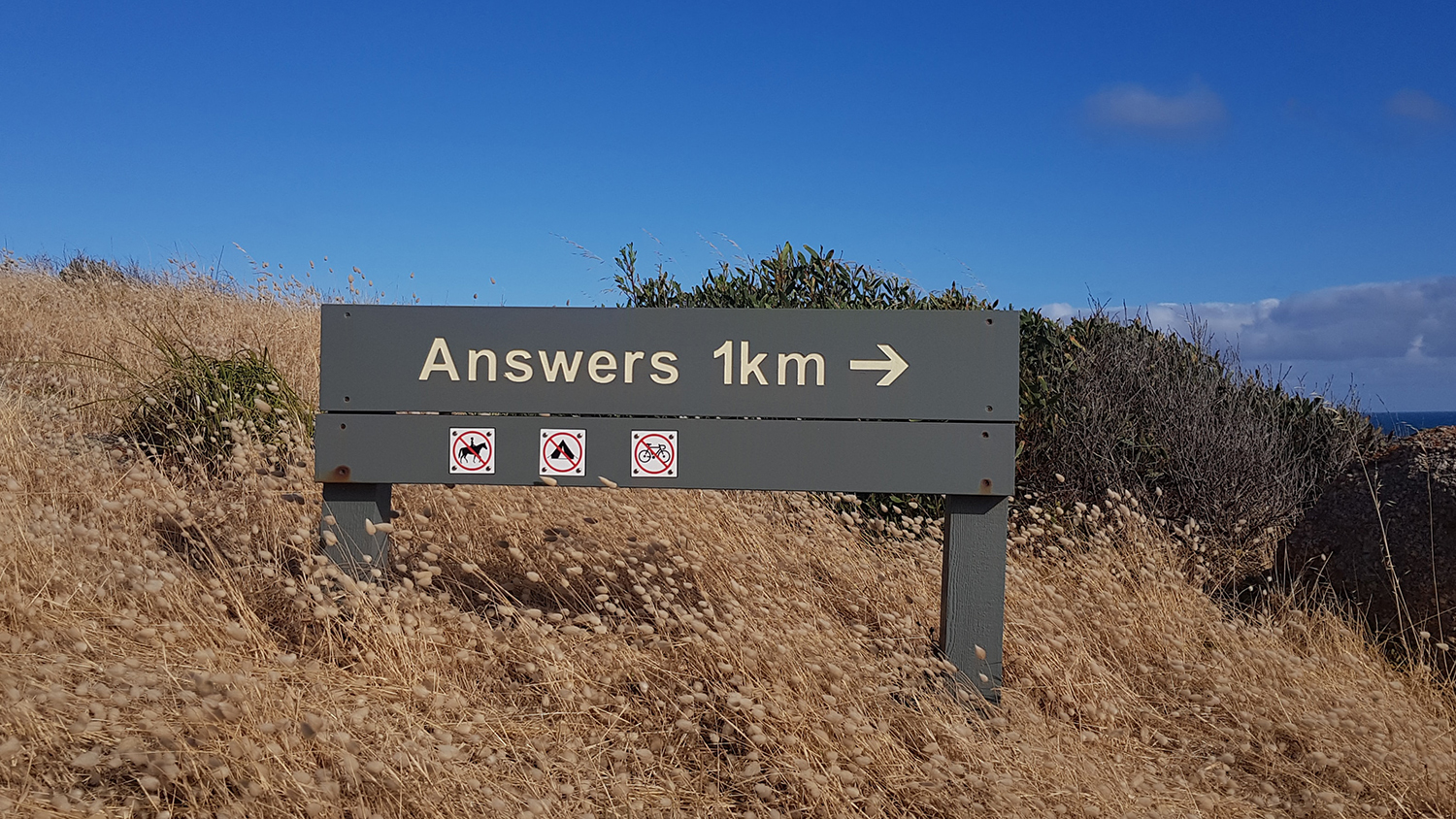 roadsign saying answers in 1 kilometre